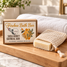 Load image into Gallery viewer, Firebee Shea Honey Oatmeal Bath Bar with a sisal soap saver bag on a bathroom tray